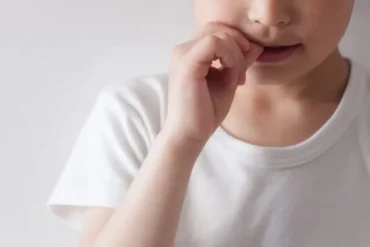 爪を噛む少年